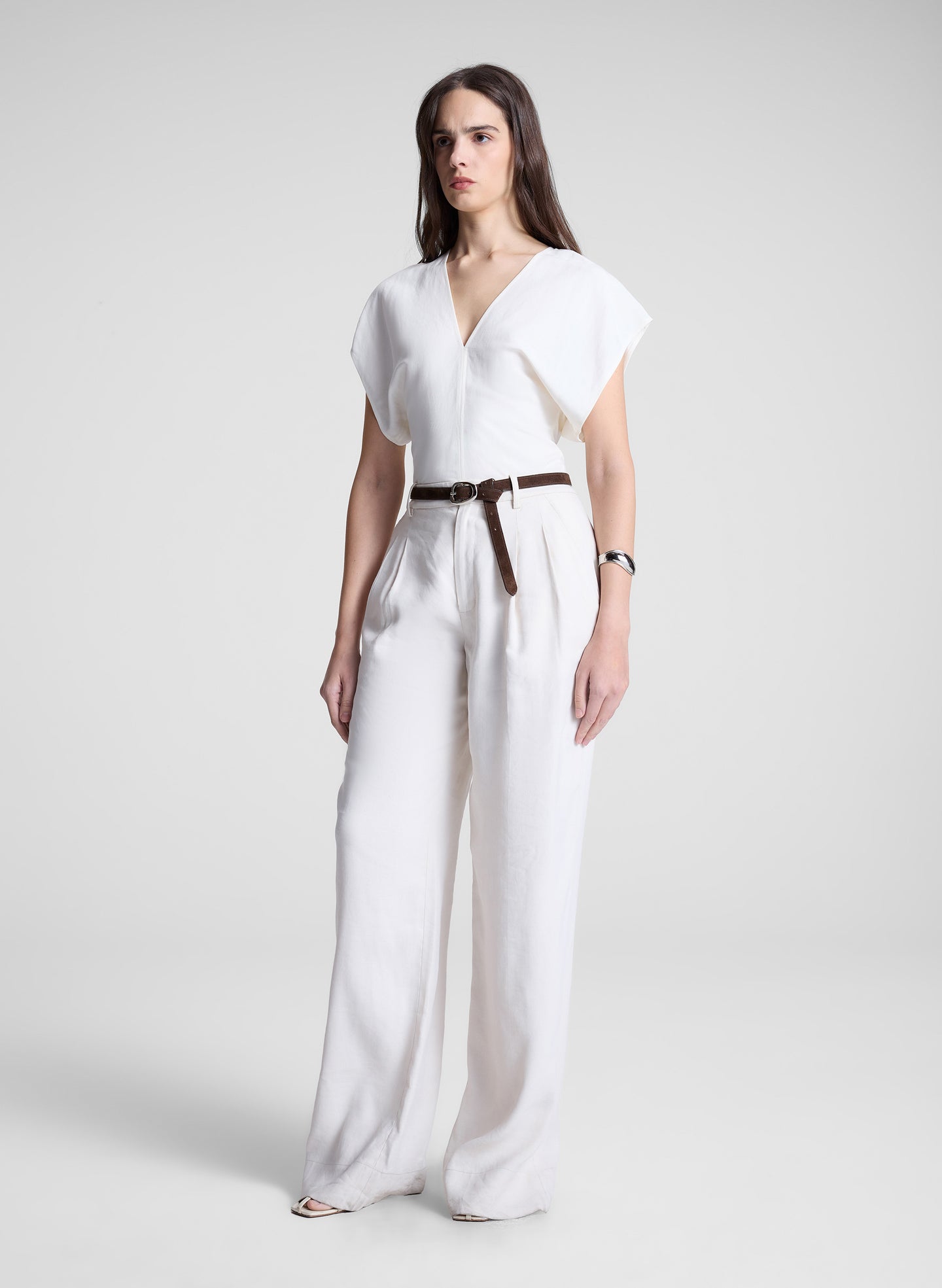woman wearing white linen top and cream wide leg pant