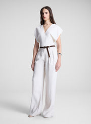 woman wearing white linen top and cream wide leg pant