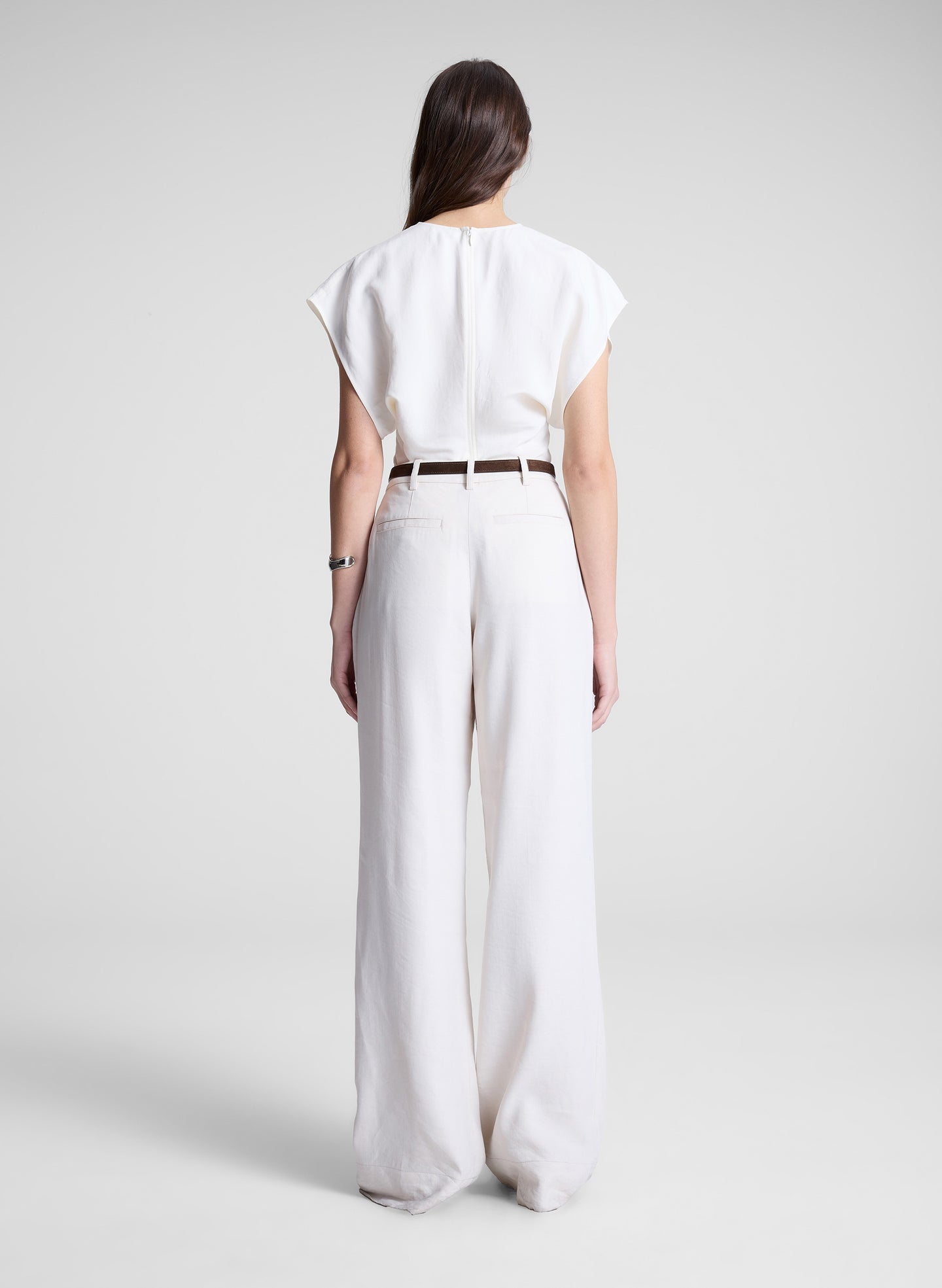 woman wearing white linen top and cream wide leg pant