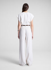 woman wearing white linen top and cream wide leg pant