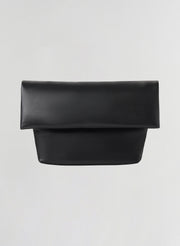 A black leather clutch bag with a wide top flap and a structured rectangular body, shown against a plain light gray background.