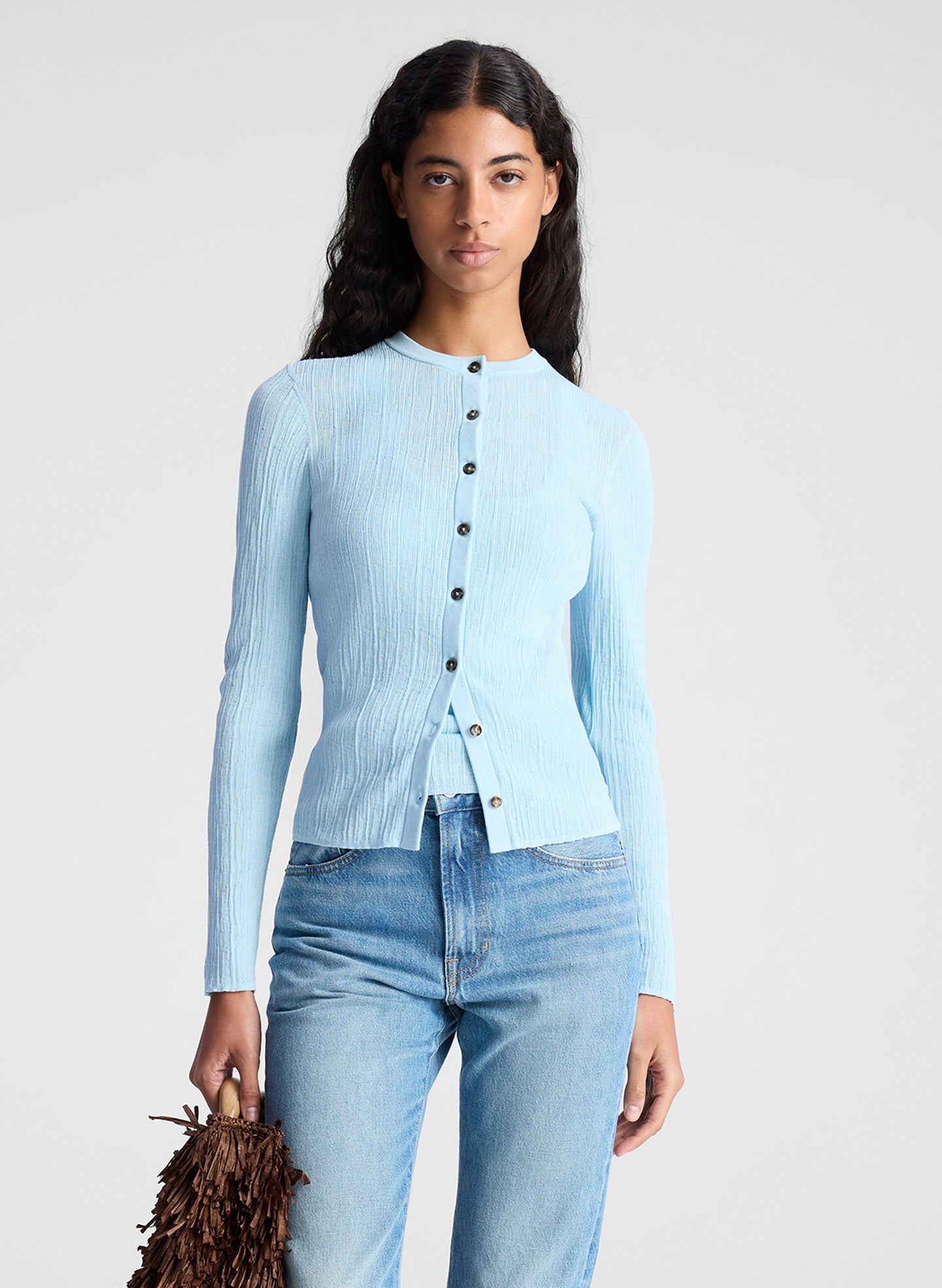 woman wearing light blue fine gauge cardigan and light blue denim jeans