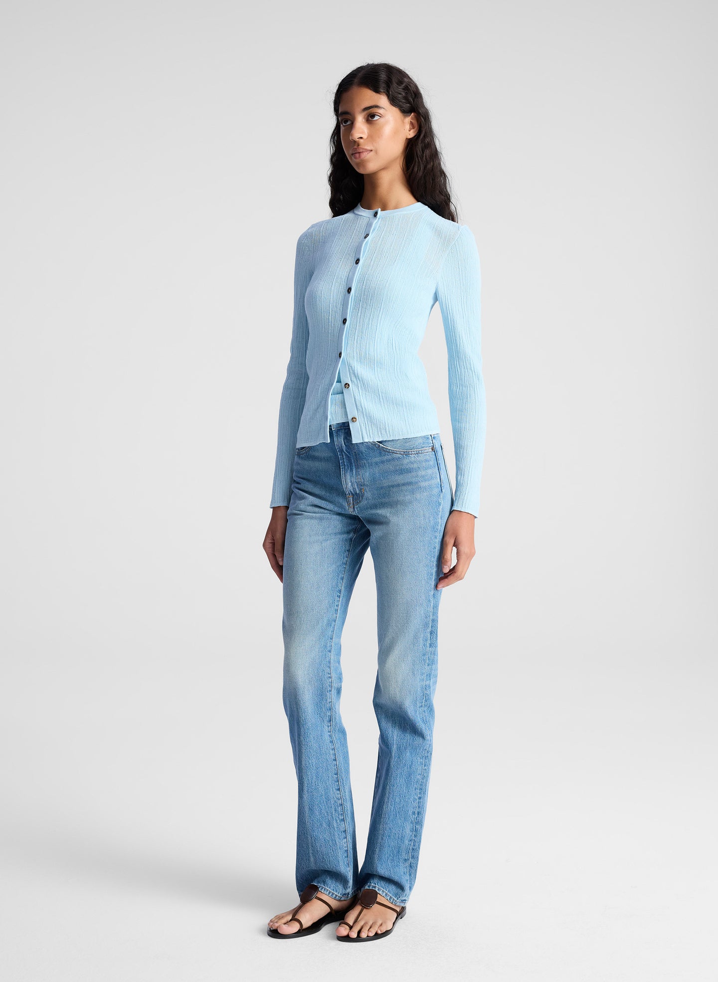 woman wearing light blue fine gauge cardigan and light blue denim jeans