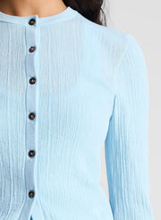 woman wearing light blue fine gauge cardigan and light blue denim jeans