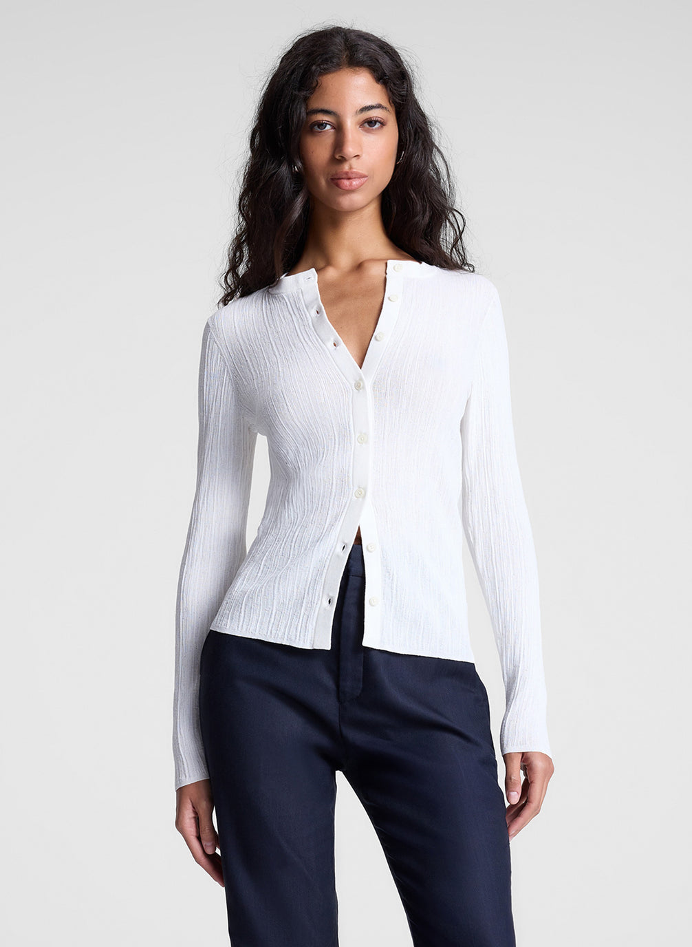 woman wearing white cardigan and navy blue pants