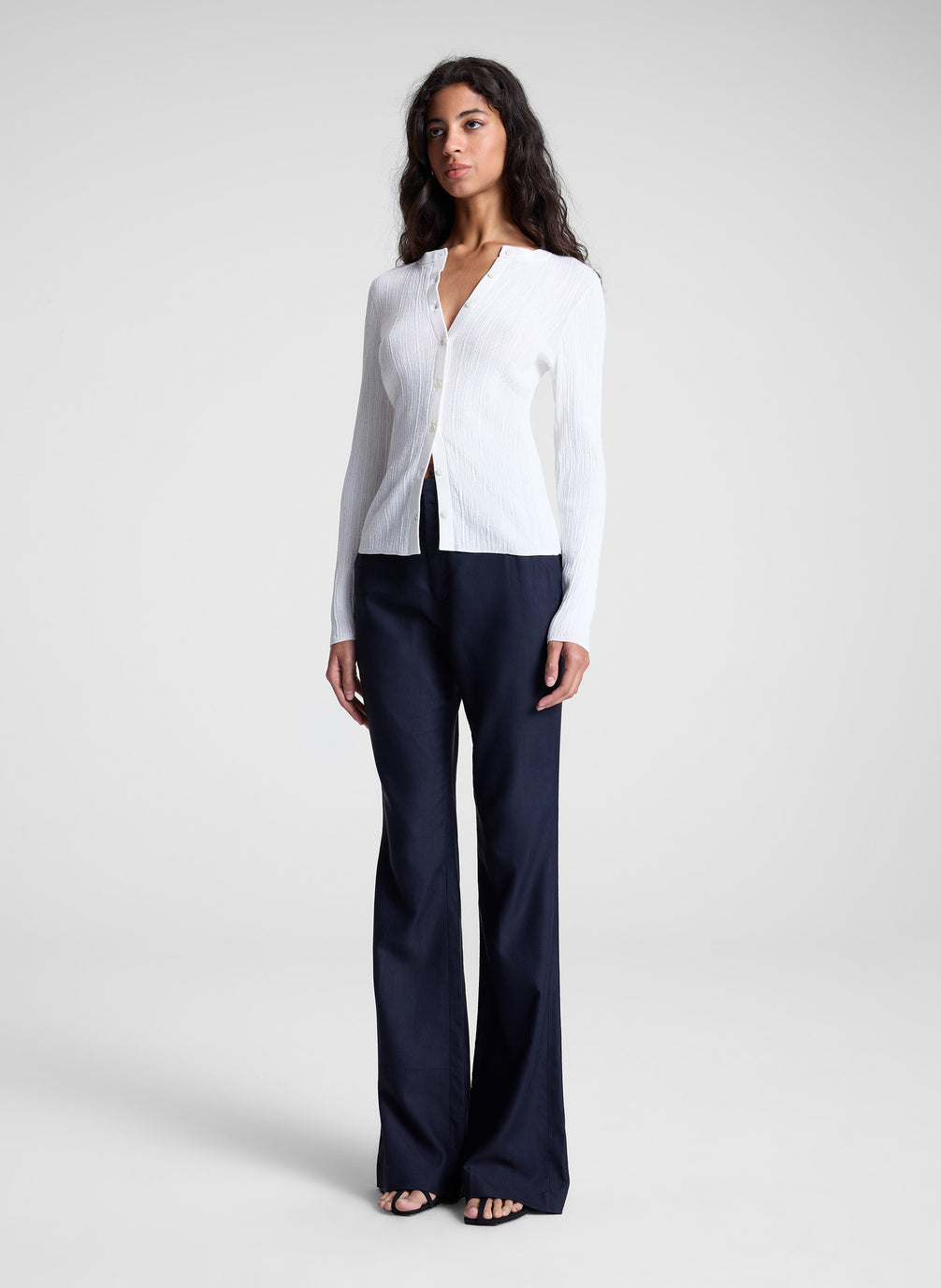 woman wearing white cardigan and navy blue pants