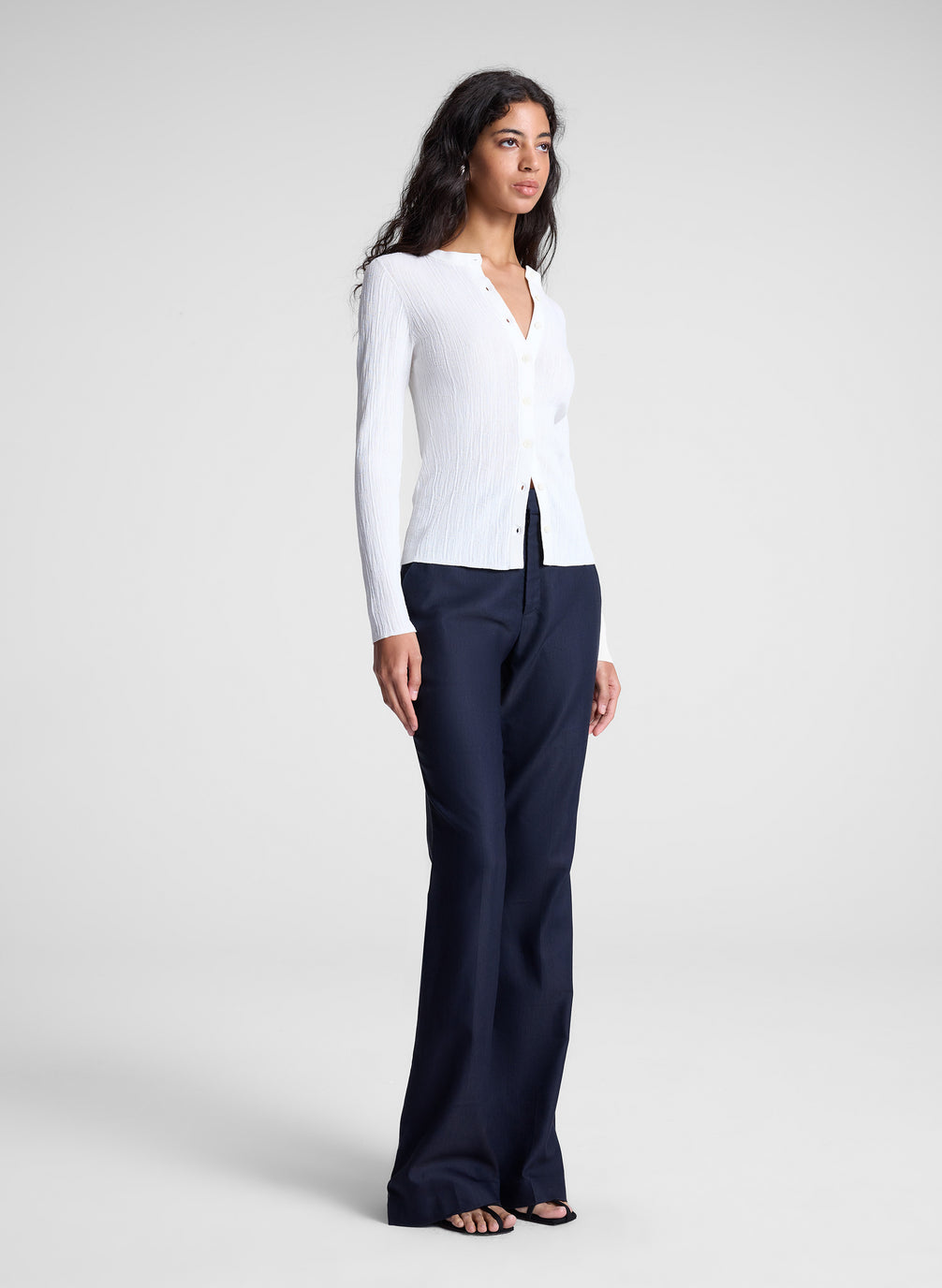 woman wearing white cardigan and navy blue pants