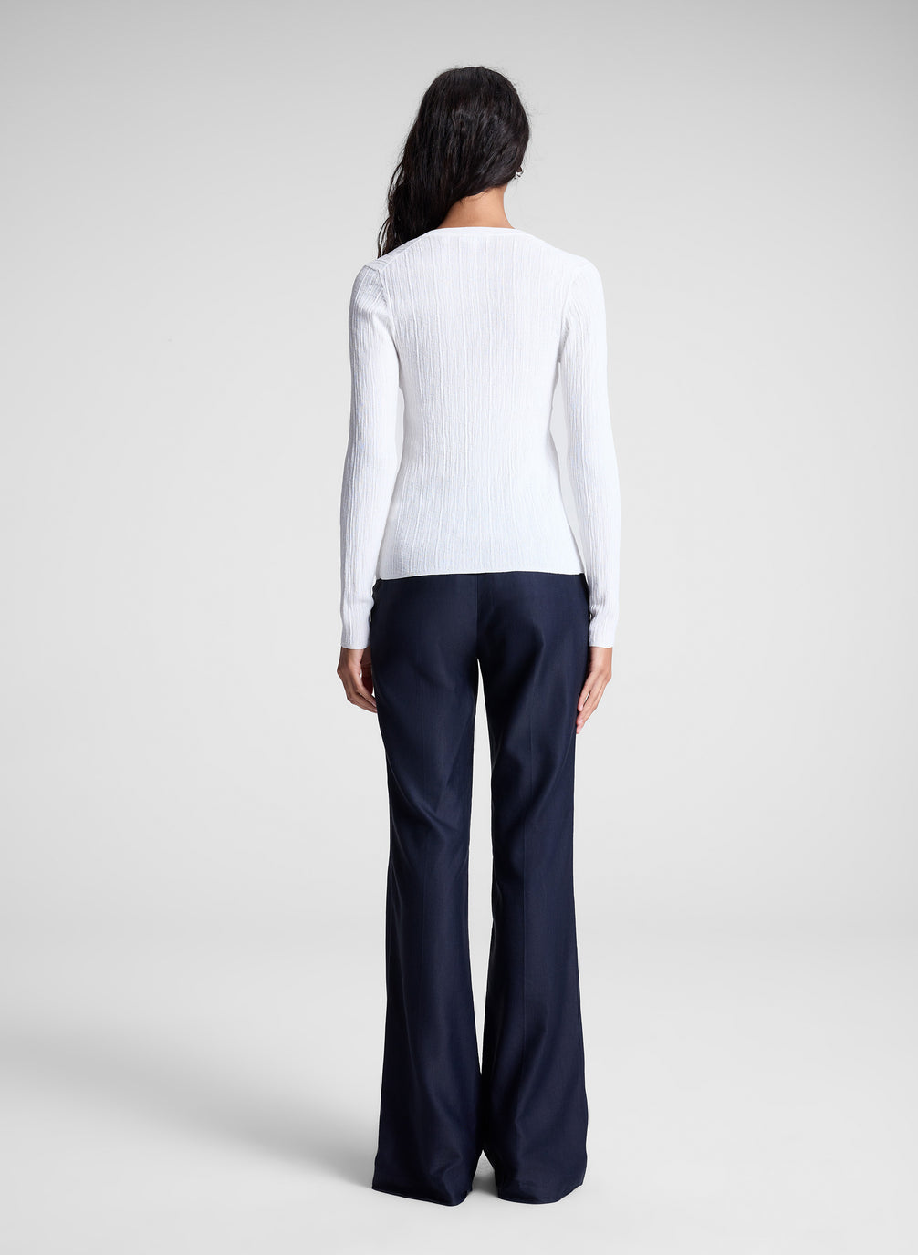 woman wearing white cardigan and navy blue pants