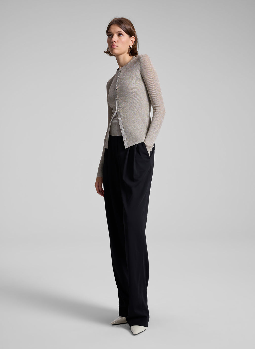 woman wearing gold cardigan and black pants