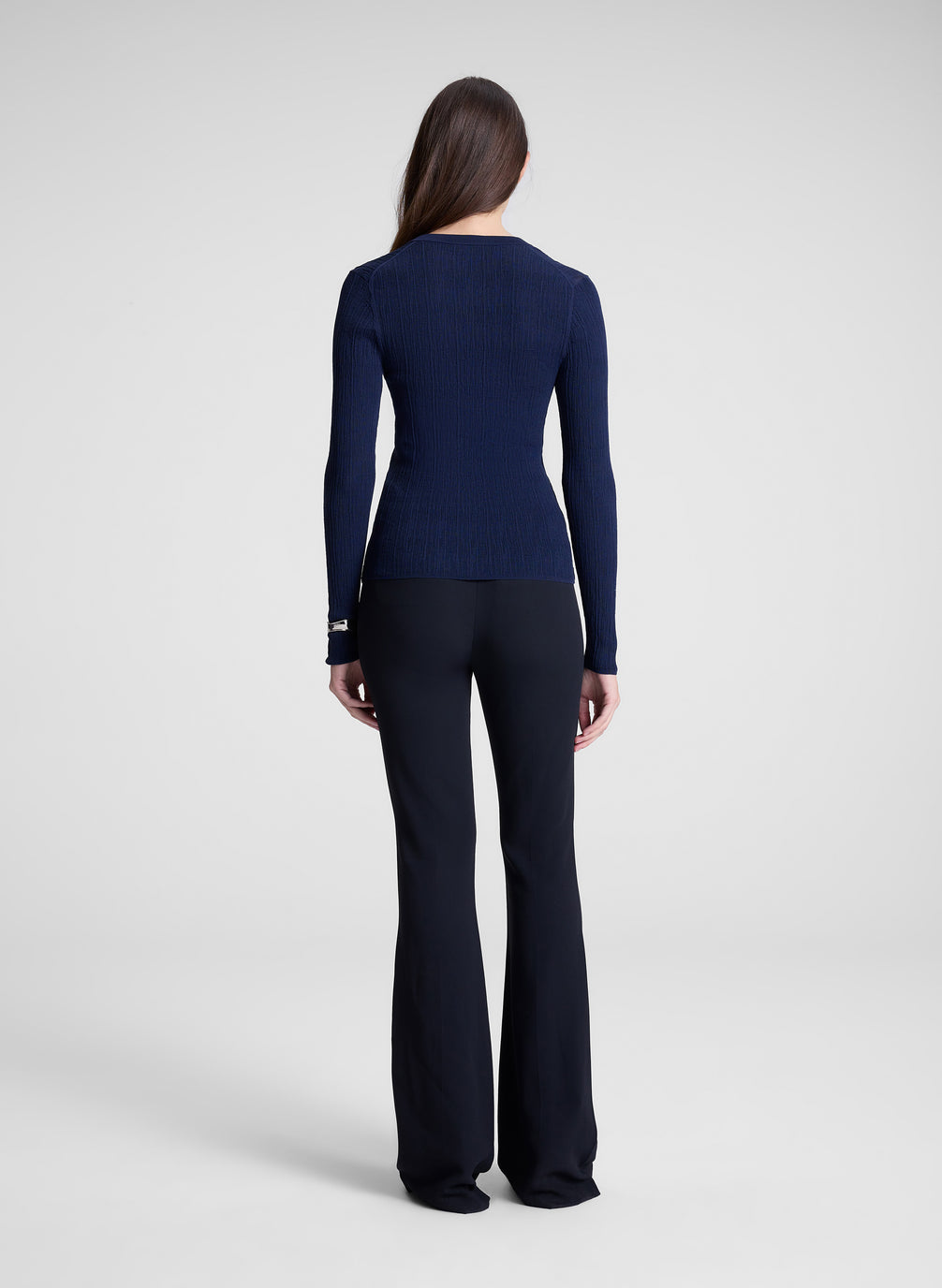 woman wearing navy cardigan and black pants