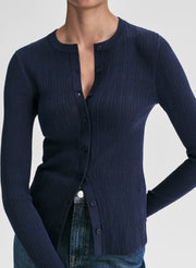 Navy blue ribbed cardigan worn by a person on a light gray background
