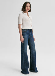 Woman wearing a white top and blue jeans on a white background