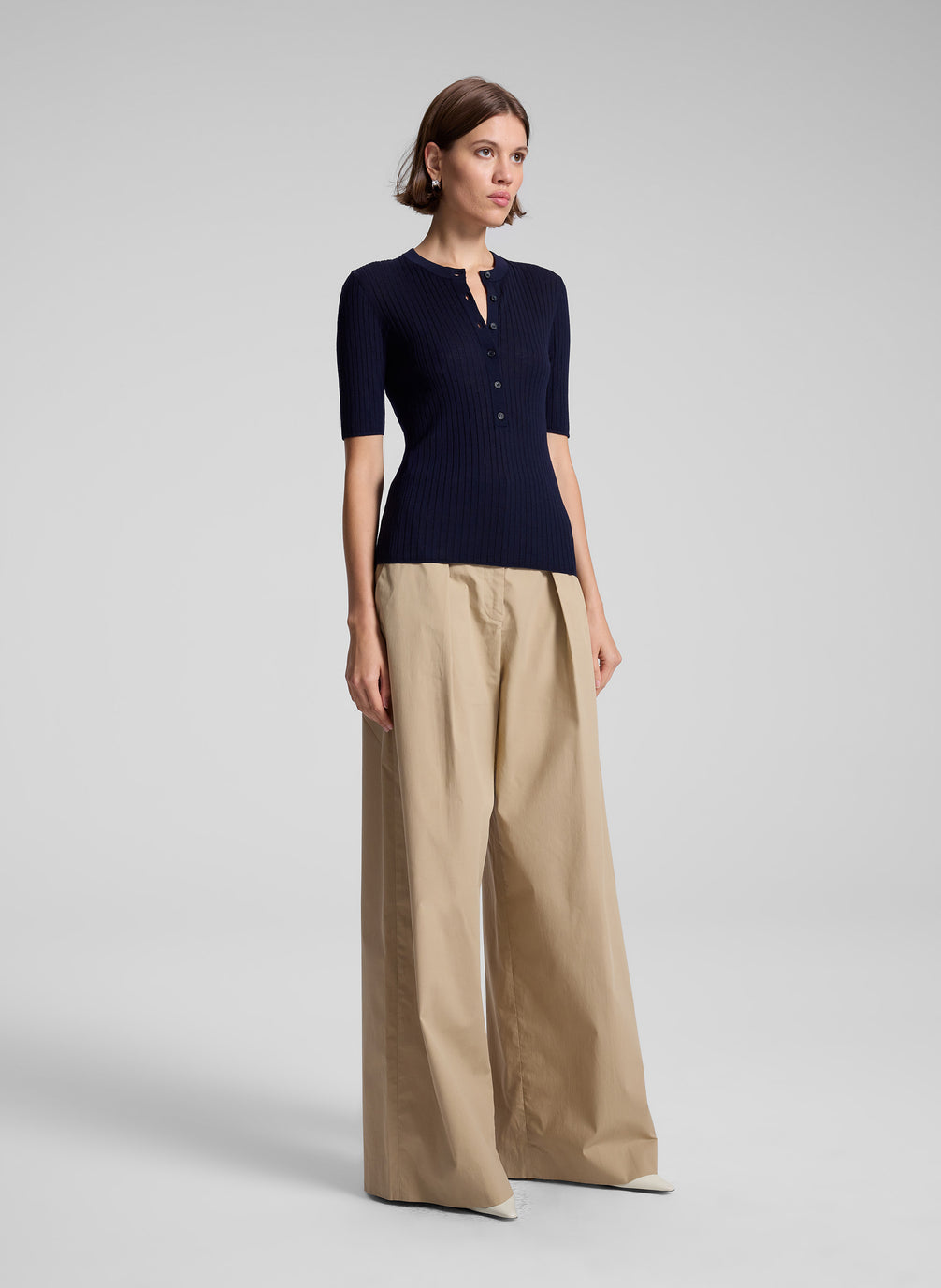 woman wearing navy blue top and tan pants