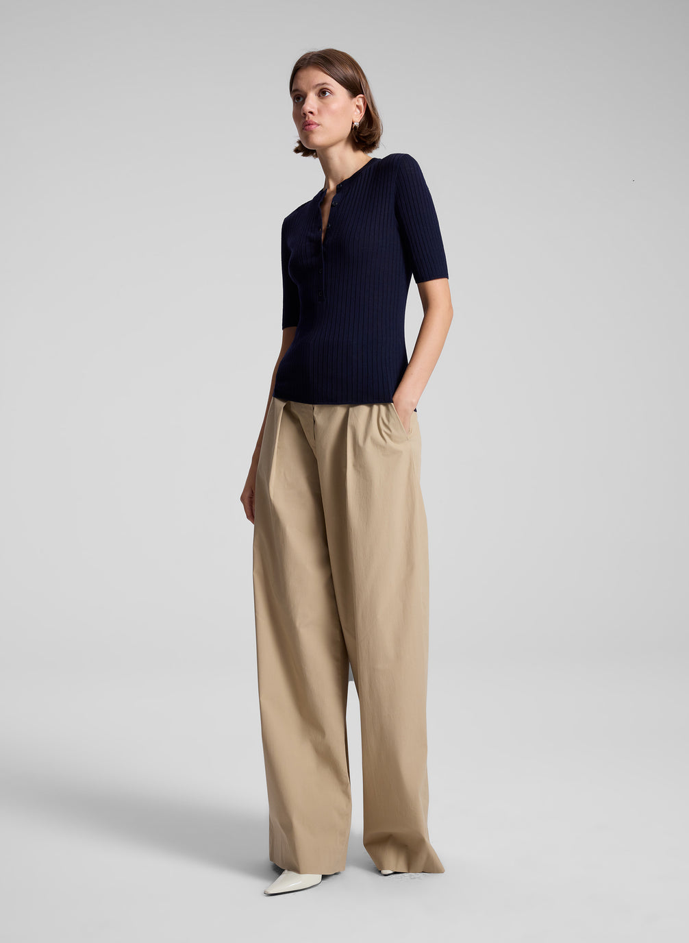 woman wearing navy blue top and tan pants