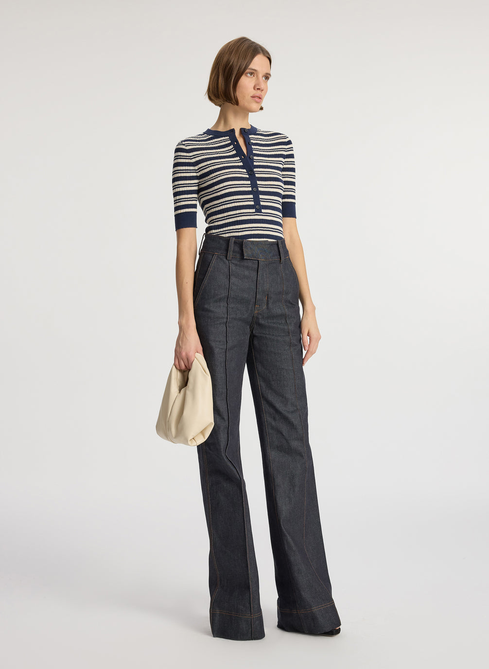 front  view of woman wearing navy blue striped half sleeve button placket shirt and dark wash raw denim jean