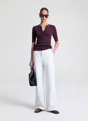 woman wearing purple fine gauge voile knit top and white denim jeans