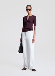woman wearing purple fine gauge voile knit top and white denim jeans