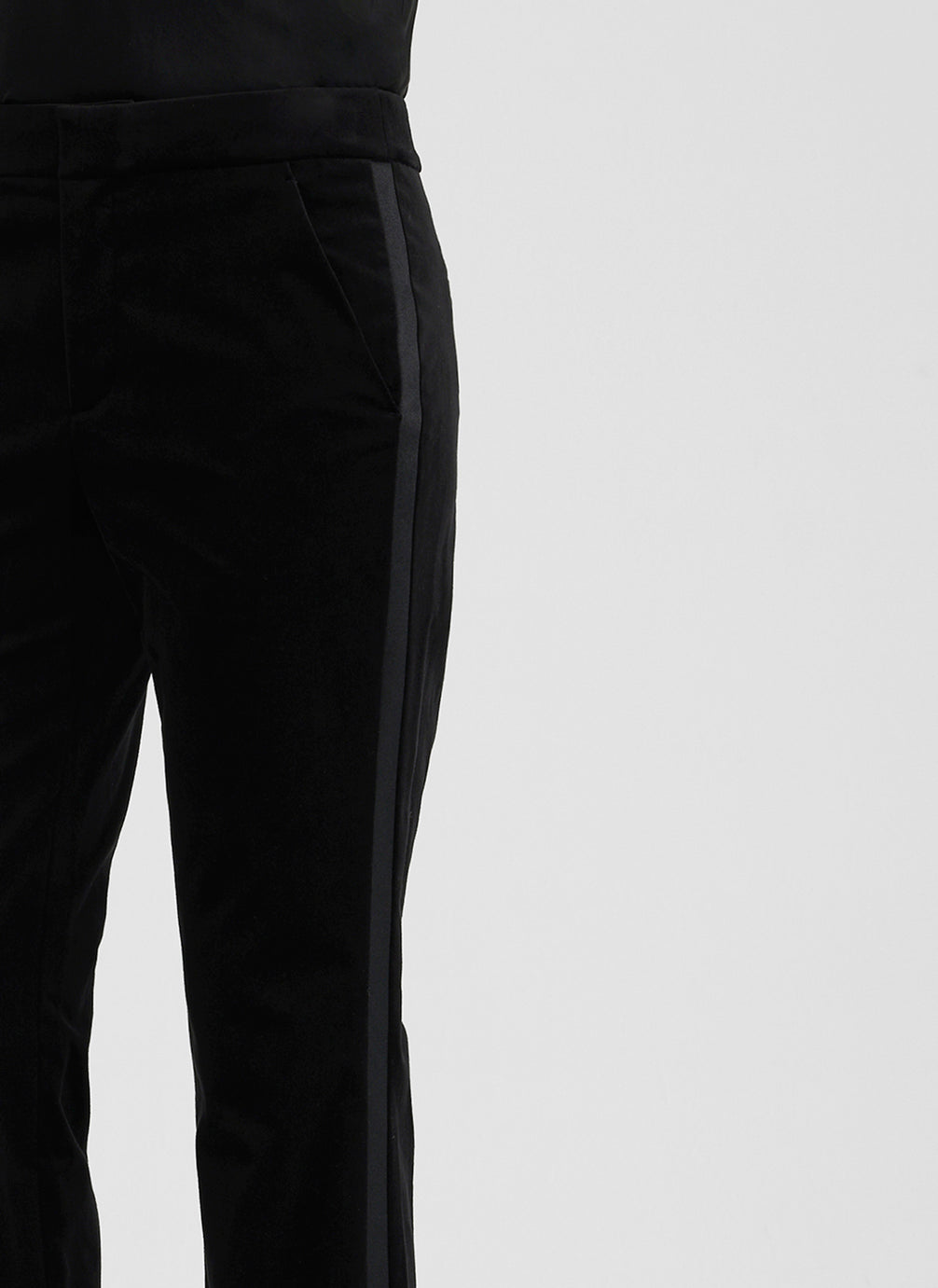 detail view of woman wearing black satin camisole and black velvet pants