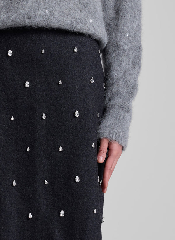 woman wearing grey embellished sweater and grey embellished skirt