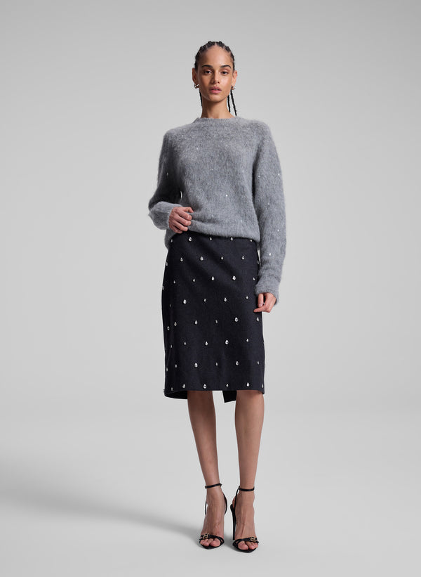 woman wearing grey embellished sweater and grey embellished skirt