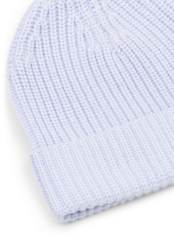 detail view of woman wearing light blue knit beanie