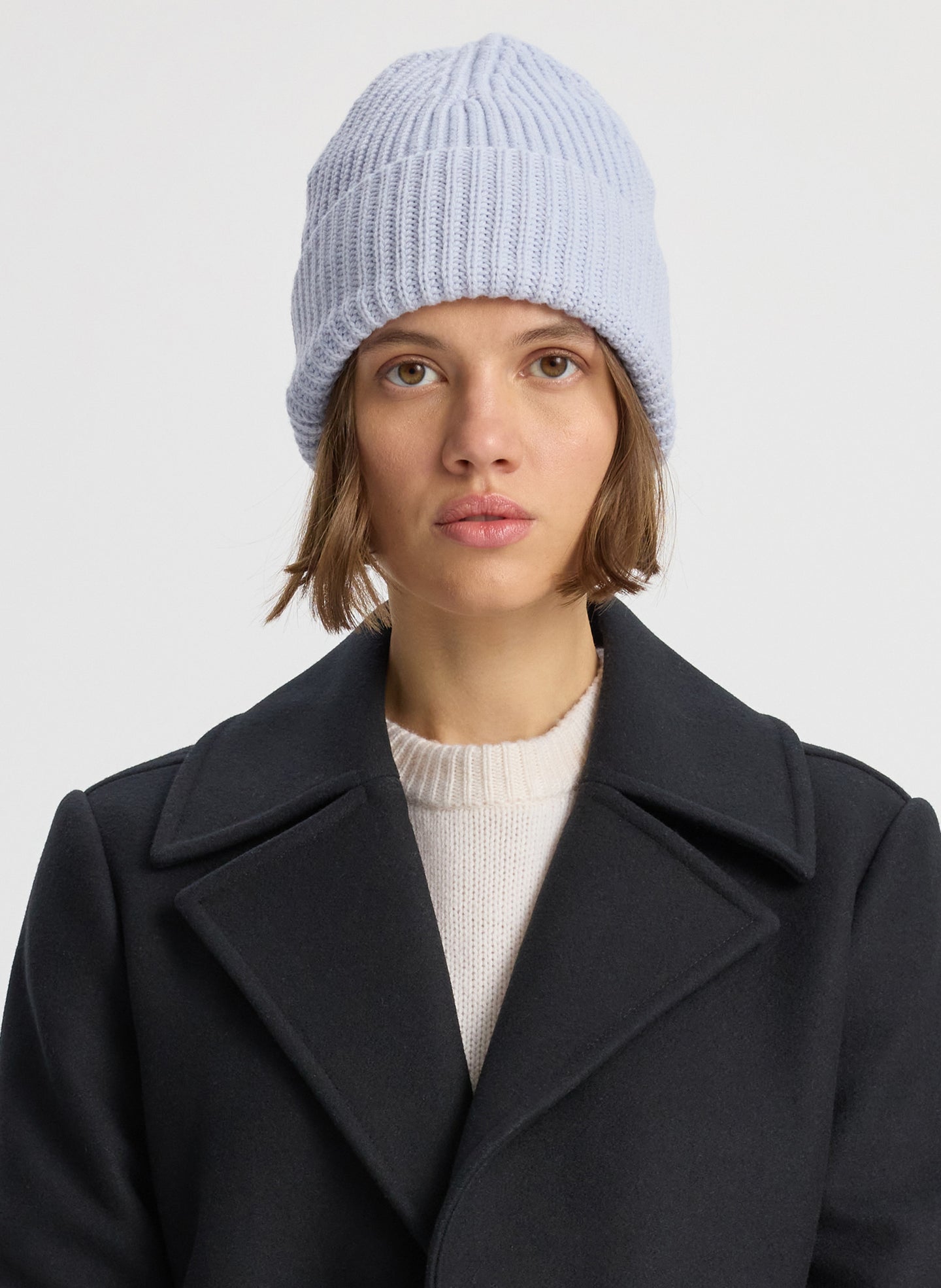 Front view of woman wearing light blue knit beanie