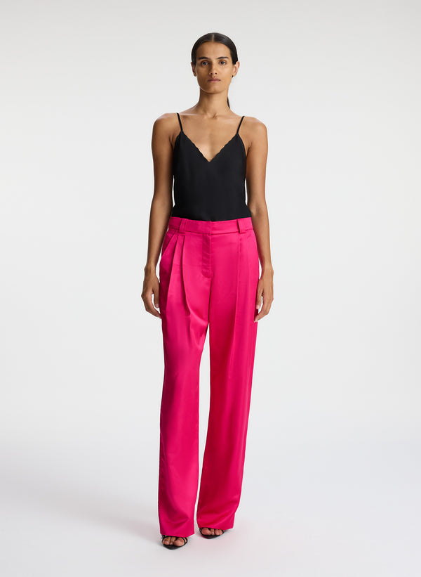 front view of woman wearing black satin camisole with bright pink satin pants