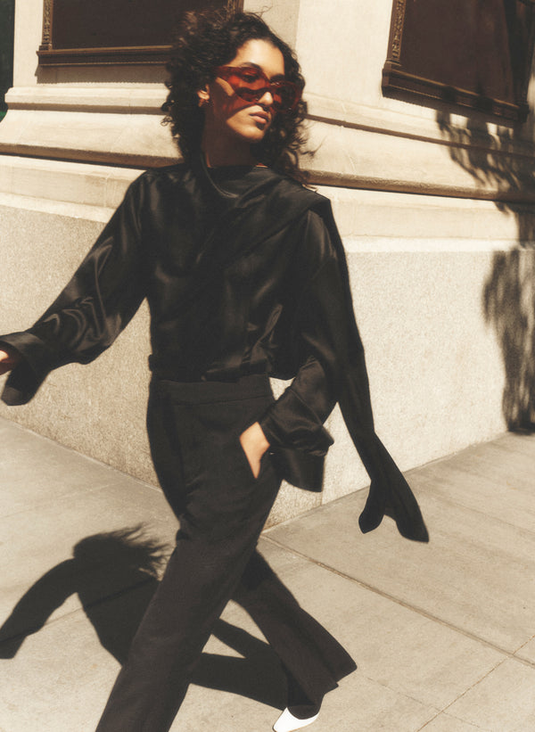 woman wearing back draped silk top and black pants
