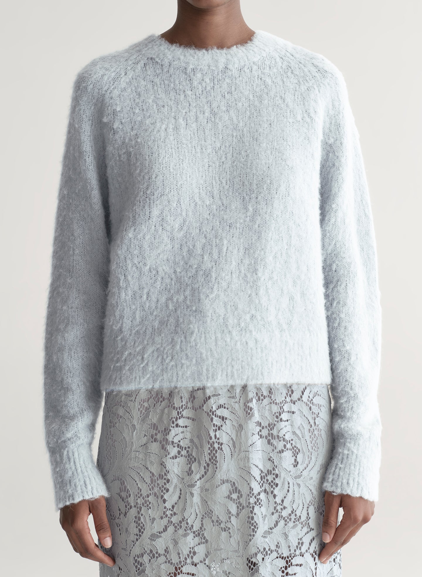 woman wearing light blue sweater with light blue lace skirt