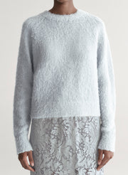 woman wearing light blue sweater with light blue lace skirt