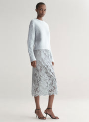 woman wearing light blue sweater with light blue lace skirt