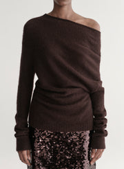 Woman wearing a brown off-shoulder sweater with a sequined midi skirt