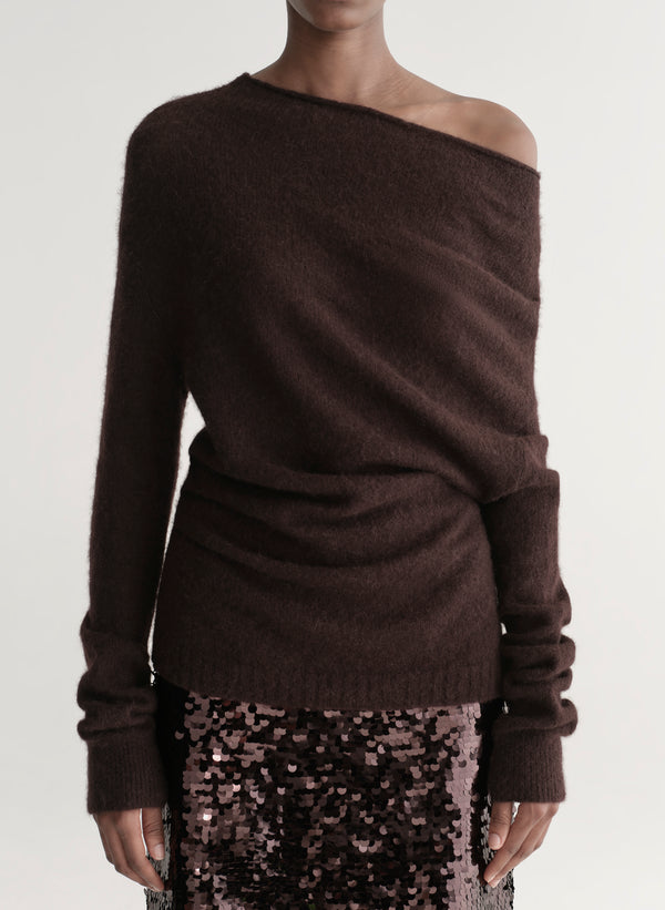 Woman wearing a brown off-shoulder sweater with a sequined midi skirt