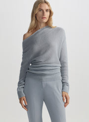 Gray off-shoulder sweater worn by a person on a plain background