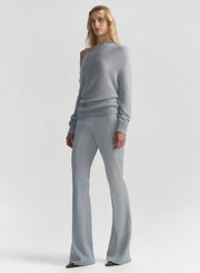 Woman wearing a gray sweater and pants on a white background