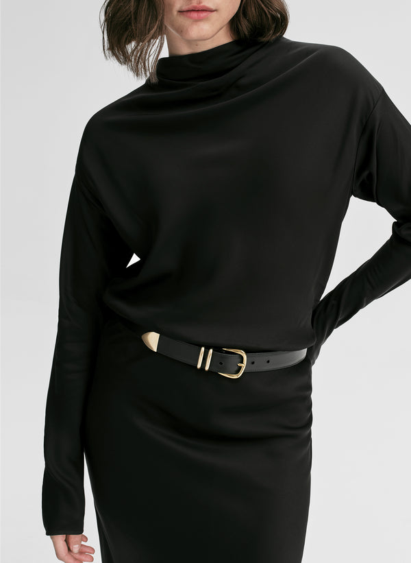 Person wearing a black long-sleeve top with a belt on a white background