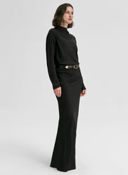 Woman wearing a black outfit with a belt on a white background