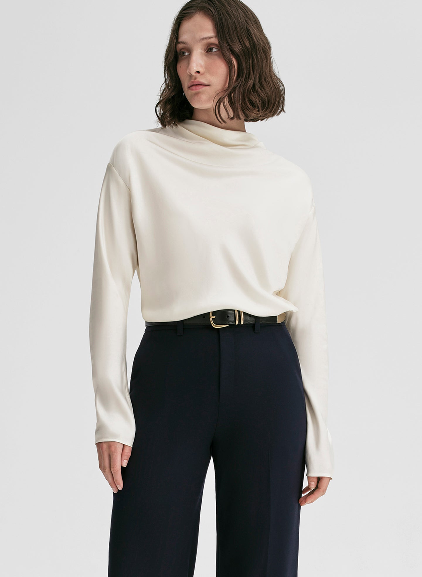 woman wearing white satin top and navy blue pants