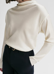woman wearing white satin top and navy blue pants