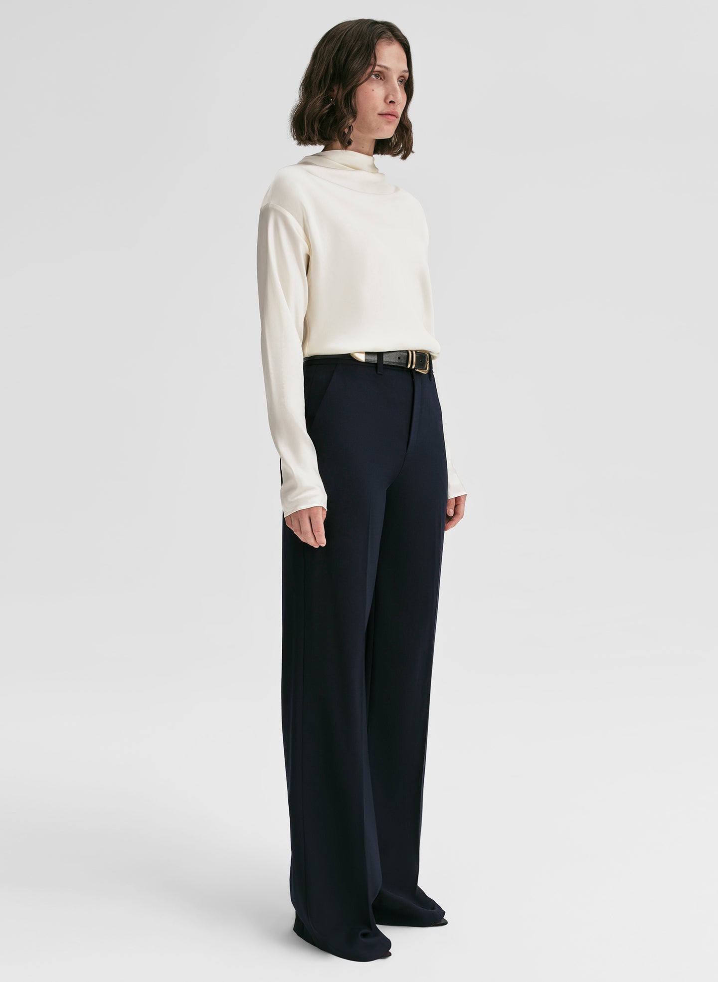 woman wearing white satin top and navy blue pants
