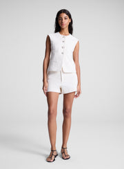 woman wearing white vest and matching shorts