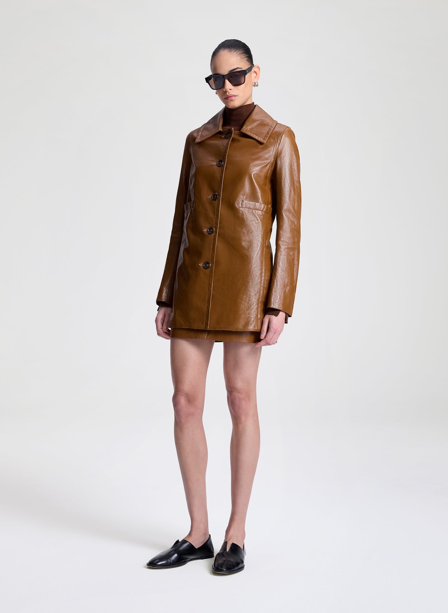 woman wearing brown leather jacket and matching mini skirt