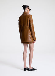 woman wearing brown leather jacket and matching mini skirt