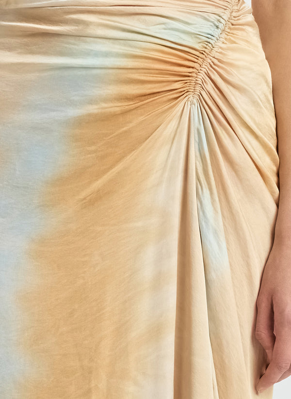 detail view of woman wearing white tank top and blue and beige midi skirt