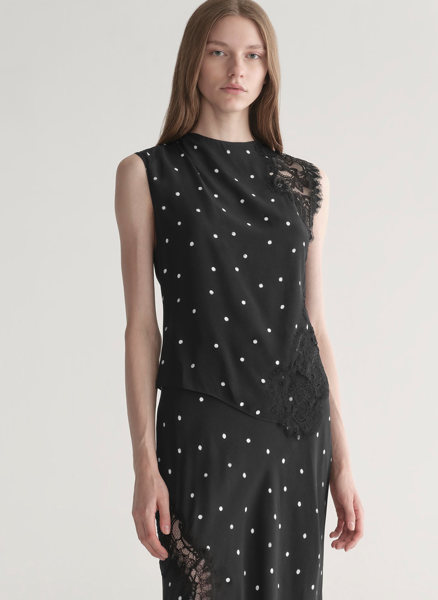 woman wearing black polka dot lace top with matching midi skirt