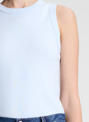 woman wearing light blue tank top and dark blue denim wide leg jeans