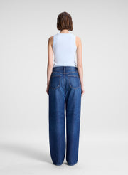 woman wearing light blue tank top and dark blue denim wide leg jeans