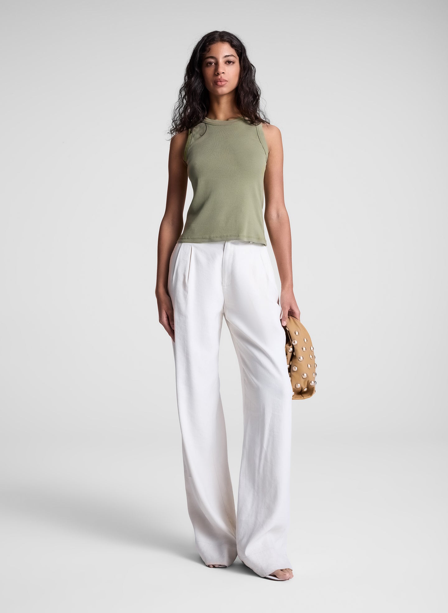 woman carrying tan studded handbag