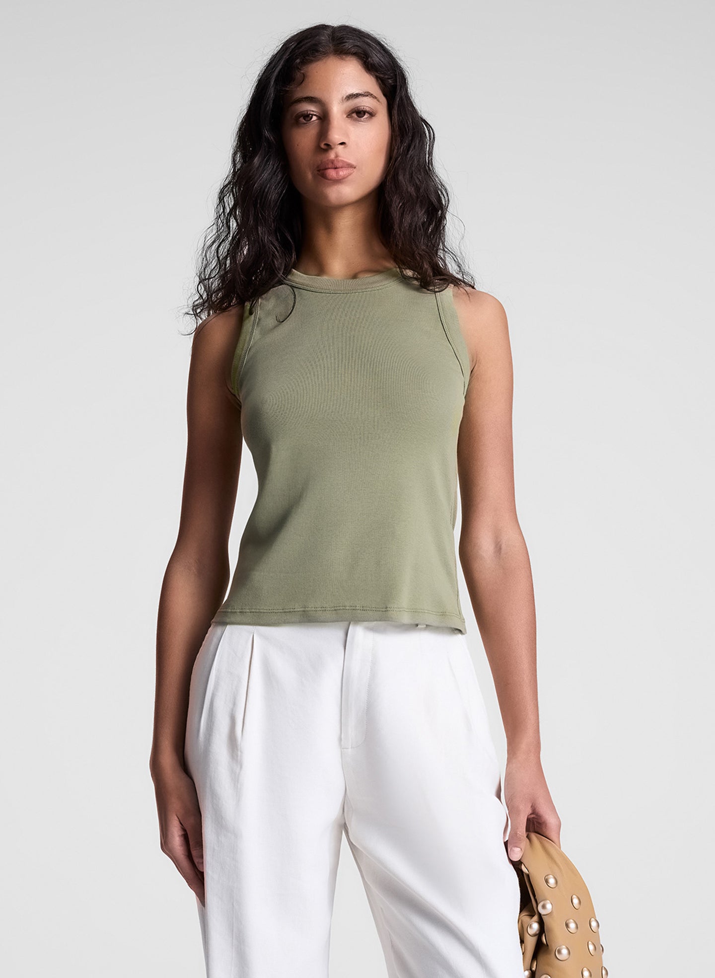 woman wearing green tank top and white pants