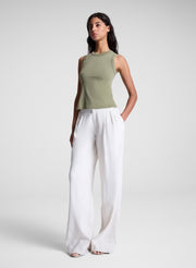 woman wearing green tank top and white pants